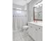Bright bathroom features a shower with a decorative curtain, plus a vanity with storage at 15107 3Rd E Dr, Bradenton, FL 34212