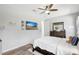 Inviting bedroom with wood floors, a ceiling fan, a wall-mounted TV, and stylish furniture at 15107 3Rd E Dr, Bradenton, FL 34212