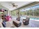 Screened-in lanai features wicker furniture and access to a sparkling pool in a tropical setting at 15107 3Rd E Dr, Bradenton, FL 34212