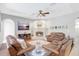 Inviting living room featuring a fireplace, ceiling fan and comfortable leather furniture at 15107 3Rd E Dr, Bradenton, FL 34212