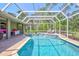 Sparkling in-ground pool surrounded by a screened enclosure and outdoor lounge chairs at 15107 3Rd E Dr, Bradenton, FL 34212