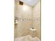 Modern shower stall featuring neutral tile, a pebble floor, and a built-in seat for comfort at 15107 3Rd E Dr, Bradenton, FL 34212