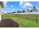 Fenced backyard featuring lush green grass and a black metal fence surrounding the property at 16016 Sunny Day Dr, Bradenton, FL 34211