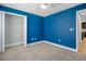 This bedroom features blue accent walls, plush carpeting, and a large walk in closet at 1602 E Mulberry Dr, Tampa, FL 33604
