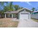 Charming single-story home with a one-car garage and a well-maintained front yard and light green paint at 1602 E Mulberry Dr, Tampa, FL 33604