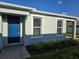 Home exterior featuring a blue entry door, neutral siding, windows with blinds and a brick walkway at 16120 Ivy Ridge Ct, Port Charlotte, FL 33953