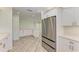 Modern kitchen boasts stainless steel appliances, sleek white cabinetry, and flows into living area at 2601 13Th W St, Palmetto, FL 34221