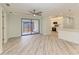 Bright living room leading to kitchen with sliding glass doors and gray wood look floors at 2601 13Th W St, Palmetto, FL 34221