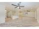 Open living room featuring sliding glass doors, ceiling fan, and neutral paint, flowing into the kitchen at 2601 13Th W St, Palmetto, FL 34221
