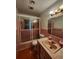 Retro bathroom with pink tile, bathtub with sliding glass door, and vintage fixtures at 2727 Waldemere St, Sarasota, FL 34239