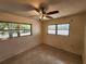 Bedroom with a ceiling fan, two windows and neutral-colored walls and flooring at 2727 Waldemere St, Sarasota, FL 34239