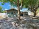 Charming single-story home with mature trees providing shade, a white fence, and a well-kept lawn at 2727 Waldemere St, Sarasota, FL 34239