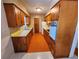 Retro kitchen featuring wood cabinets, a yellow countertop, a white refrigerator, and orange flooring at 2727 Waldemere St, Sarasota, FL 34239