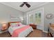 Cozy bedroom featuring a ceiling fan, a window with white shutters, and warm nautical-themed decor accents at 275 Sapphire Lake Dr # 101, Bradenton, FL 34209