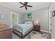 Cozy bedroom with coastal decor, a comfortable bed, and natural light filtering through the window with a ceiling fan at 275 Sapphire Lake Dr # 101, Bradenton, FL 34209