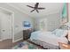 Cozy bedroom featuring a ceiling fan, a TV, a comfy bed with blue accents and a tropical-themed rug at 275 Sapphire Lake Dr # 101, Bradenton, FL 34209
