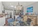 Open-concept dining area with glass table, stylish chandelier, adjacent to the kitchen and living area at 275 Sapphire Lake Dr # 101, Bradenton, FL 34209
