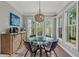 Bright dining area with a glass table and stylish wicker chairs with a unique chandelier and a coffee station nearby at 275 Sapphire Lake Dr # 101, Bradenton, FL 34209
