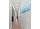 Hallway with hardwood floors, recessed lighting, and artwork leading to various rooms at 275 Sapphire Lake Dr # 101, Bradenton, FL 34209