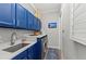 Modern laundry room with blue cabinets, granite countertops, stainless steel washer and dryer at 275 Sapphire Lake Dr # 101, Bradenton, FL 34209