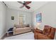 Comfortable living room with sofa, leather chair, ceiling fan, and window providing natural light at 275 Sapphire Lake Dr # 101, Bradenton, FL 34209