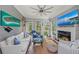 Cozy living room with a fireplace, comfortable seating, a ceiling fan, and a coastal-themed decor with lots of natural light at 275 Sapphire Lake Dr # 101, Bradenton, FL 34209