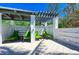 Relaxing outdoor patio featuring comfortable green lounge chairs, shaded by a pergola, providing an inviting space for leisure at 275 Sapphire Lake Dr # 101, Bradenton, FL 34209
