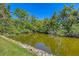 A placid pond is lined with boulders and lush vegetation in a verdant setting at 2839 Swifton Dr # 28, Sarasota, FL 34231