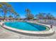 Outdoor community pool surrounded by palm trees and lounge chairs, with access to a pool house at 2839 Swifton Dr # 28, Sarasota, FL 34231