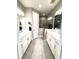 Bright bathroom featuring double sinks, white cabinetry, gray tile floors, and a glass enclosed shower at 2918 Butterfly Jasmine Trl, Sarasota, FL 34240