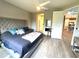 Bedroom featuring a large bed with a tufted headboard, ceiling fan, and wood floors at 2918 Butterfly Jasmine Trl, Sarasota, FL 34240