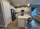 Kitchen island with bar stool seating and stainless steel appliances at 2918 Butterfly Jasmine Trl, Sarasota, FL 34240