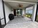 Covered screened-in patio with brick pavers, ceiling fan and views of landscaped backyard at 2918 Butterfly Jasmine Trl, Sarasota, FL 34240