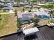 Aerial view showcases waterfront home with boat lift, well-manicured lawn, and screened lanai at 3069 Stone St, Port Charlotte, FL 33981