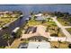 Stunning aerial view showcasing a waterfront home with a private pool and boat dock on a wide canal at 3069 Stone St, Port Charlotte, FL 33981