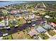 Aerial view showcasing a residential neighborhood with canal front homes, boat docks, and swimming pools at 3069 Stone St, Port Charlotte, FL 33981