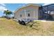 Wide shot of the home's side, boat trailer parked on the grass and screened-in patio at 3069 Stone St, Port Charlotte, FL 33981