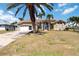 Well-maintained home with an attached two-car garage, arched entry, and lush, mature landscaping at 3069 Stone St, Port Charlotte, FL 33981