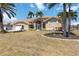 A charming tan stucco home with an attached garage, mature landscaping, and arched entry at 3069 Stone St, Port Charlotte, FL 33981