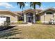 Charming home featuring a beautiful front yard, arched entry, and mature landscaping at 3069 Stone St, Port Charlotte, FL 33981