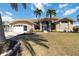 Charming single Gathering home features a well-maintained lawn and is enhanced with two palm trees at the front at 3069 Stone St, Port Charlotte, FL 33981