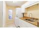 Laundry room features a stacked washer/dryer, sink, and decorative window at 3069 Stone St, Port Charlotte, FL 33981