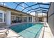 Relaxing screened-in pool area with views of the backyard and house with multiple sliding glass doors at 3069 Stone St, Port Charlotte, FL 33981
