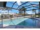 Screened-in pool offers a view of palm trees, neighboring homes and a canal at 3069 Stone St, Port Charlotte, FL 33981