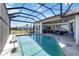 An in-ground pool is set in a screen enclosure with seating nearby at 3069 Stone St, Port Charlotte, FL 33981