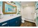 Stylish bathroom featuring blue vanity with quartz countertops, updated fixtures, and a glass enclosed shower at 336 Avenida De Mayo, Sarasota, FL 34242