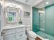 Bright bathroom featuring a glass shower with stylish tile, modern fixtures, and a decorative mirror at 336 Avenida De Mayo, Sarasota, FL 34242