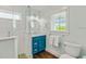 Modern bathroom with a turquoise vanity, walk-in shower, and window, offering a refreshing design at 336 Avenida De Mayo, Sarasota, FL 34242