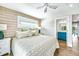 Cozy bedroom with wood-paneled accent wall, neutral decor, and a connecting bathroom with bright cabinetry at 336 Avenida De Mayo, Sarasota, FL 34242