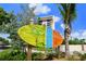 A welcoming Siesta Key Village sign in front of lush tropical plants and a building at 336 Avenida De Mayo, Sarasota, FL 34242